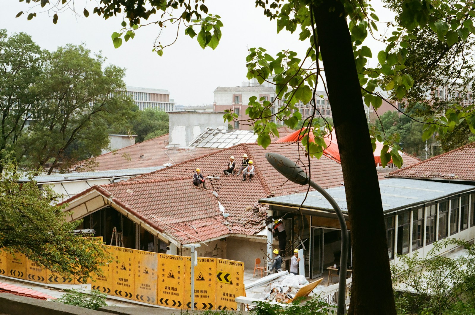 Workers repairing a damaged roof with debris